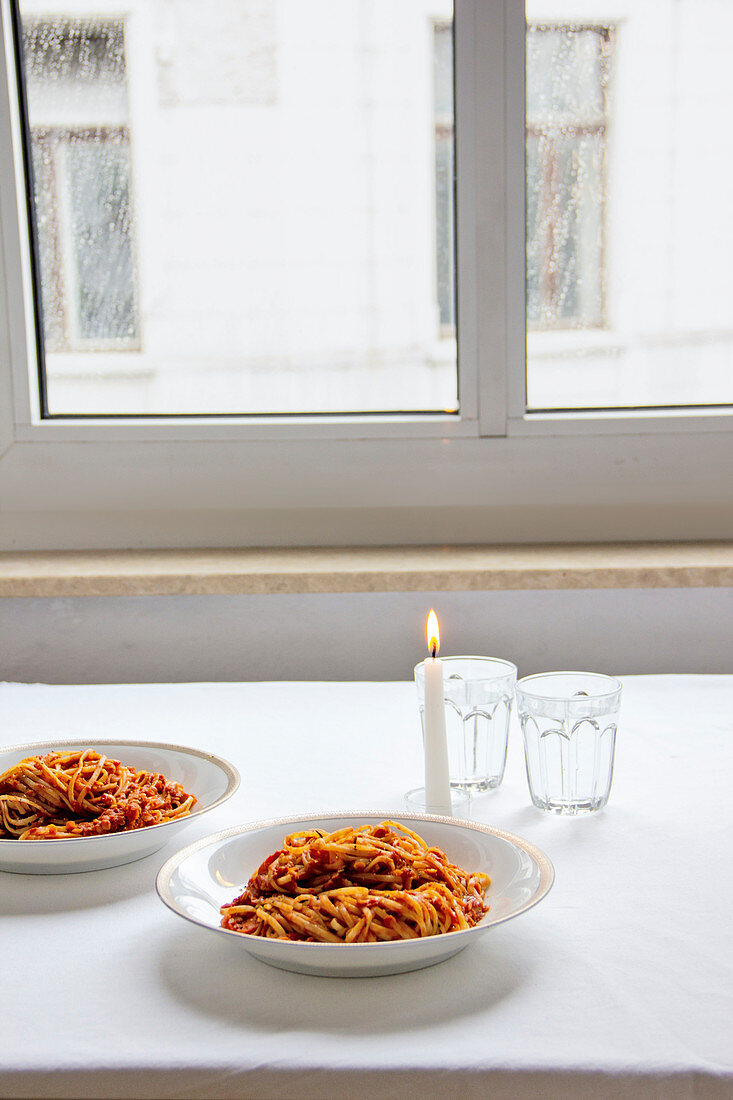 Linguine mit Linsenbolognese auf Tisch am Fenster