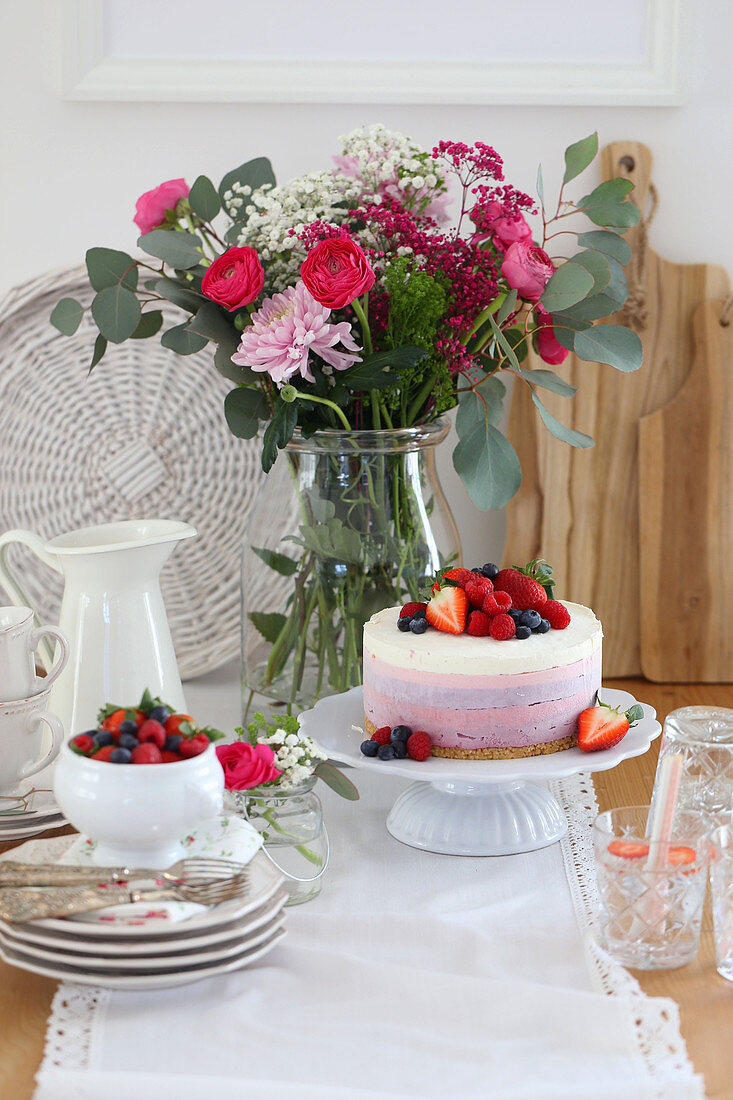 Berry cake and summer bouquet on table