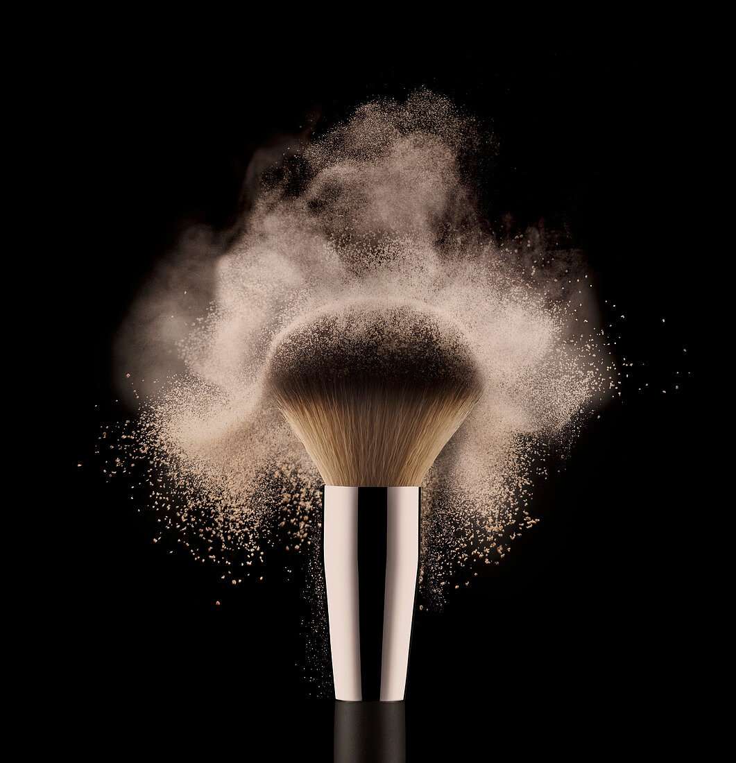 A close up of a powder brush on a black surface