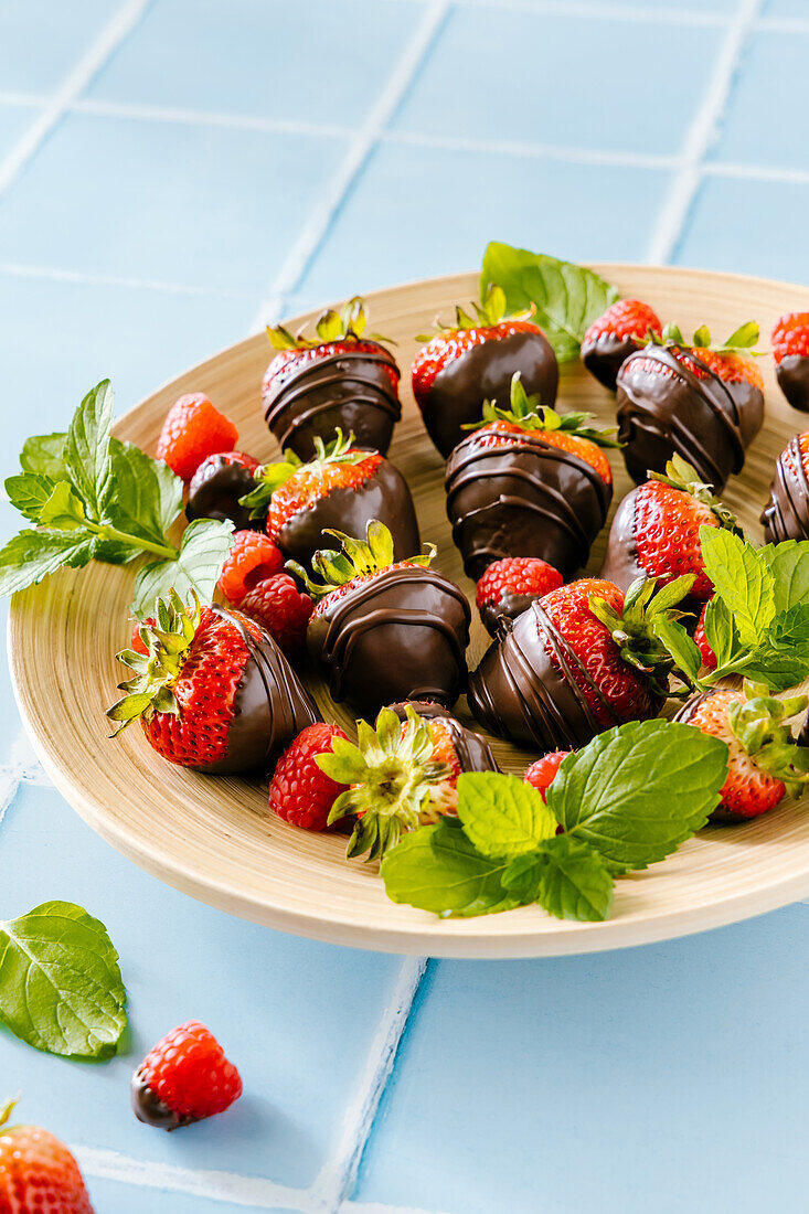 Mit dunkler Schokolade überzogene Erdbeeren und Himbeeren