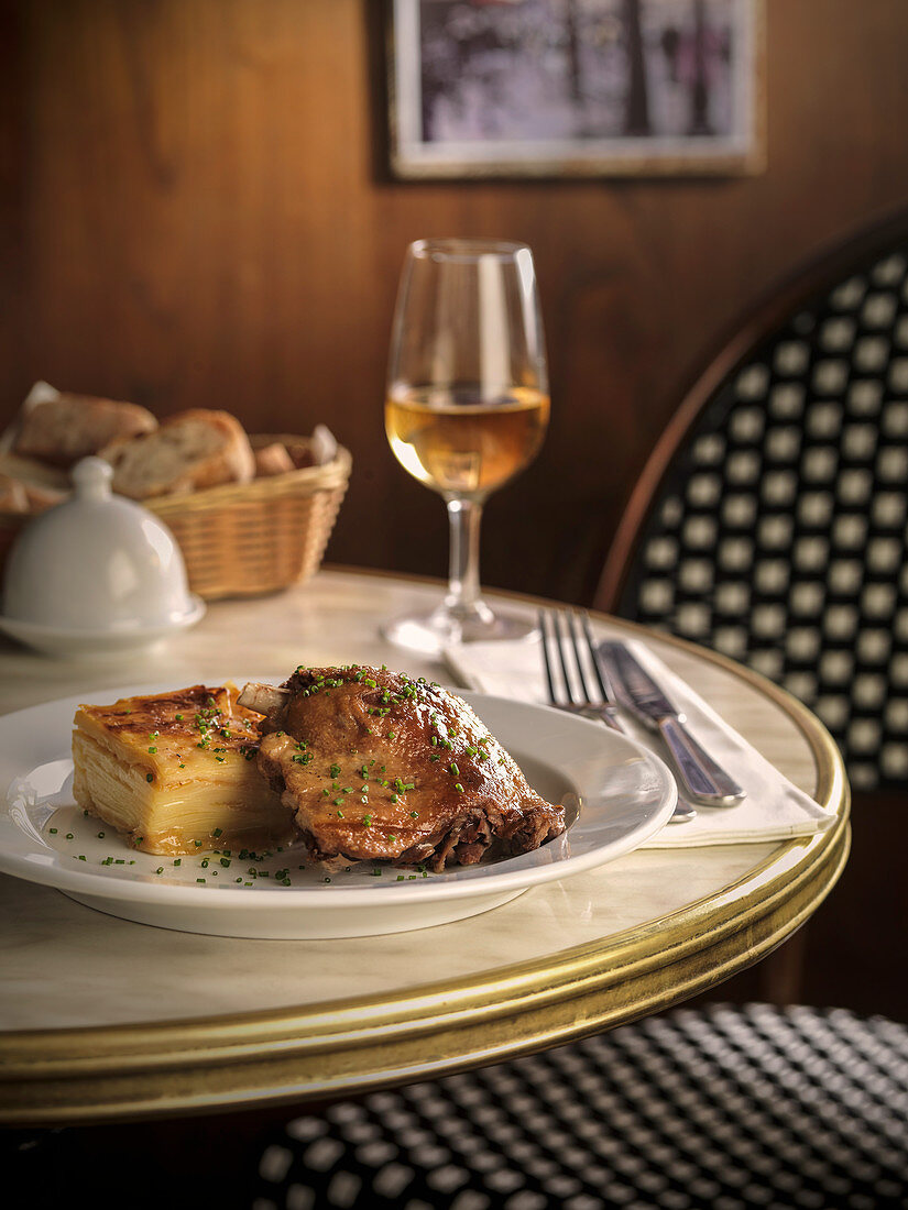 Confit de canard with potato gratin on a restaurant table