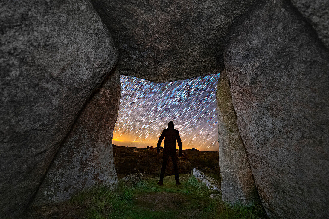 Man looking at a starry sky viewed from a dolmen, Portugal