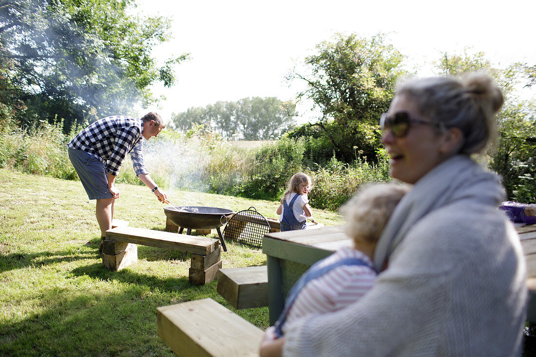 Family enjoying barbecue in sunny backyard