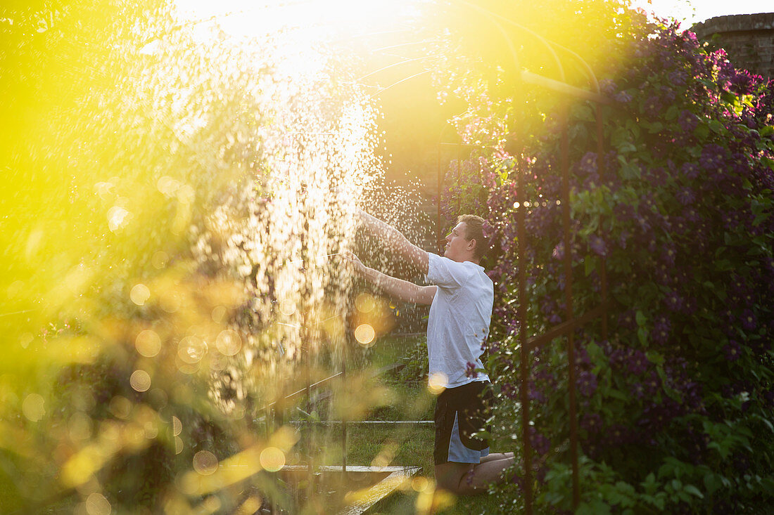 Man adjusting sprinkler in garden