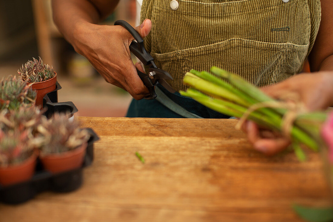 Female florist trimming flower stems with shears