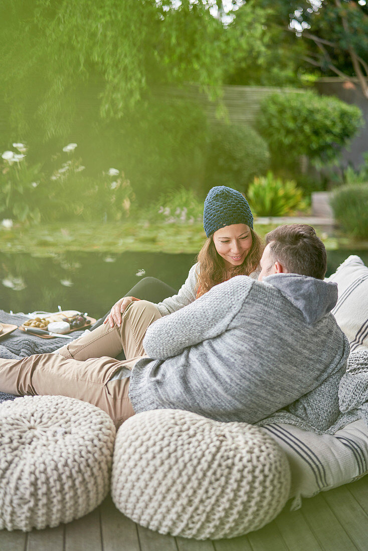 Affectionate romantic couple relaxing on patio cushions