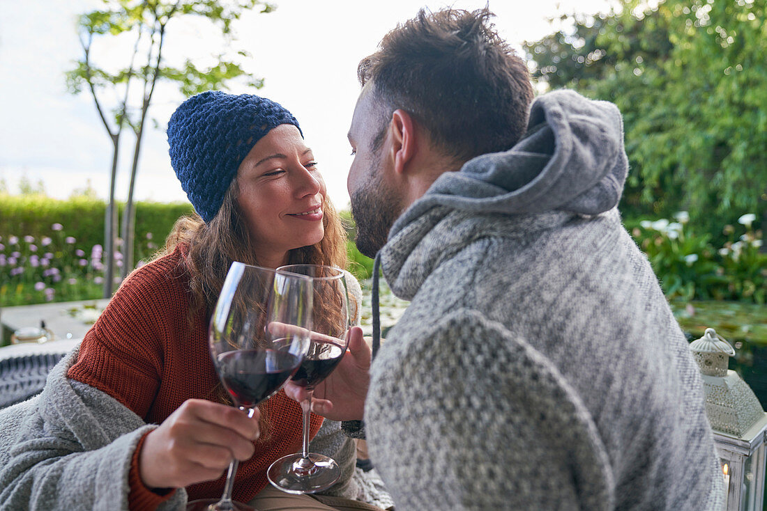 Affectionate romantic couple drinking red wine on patio