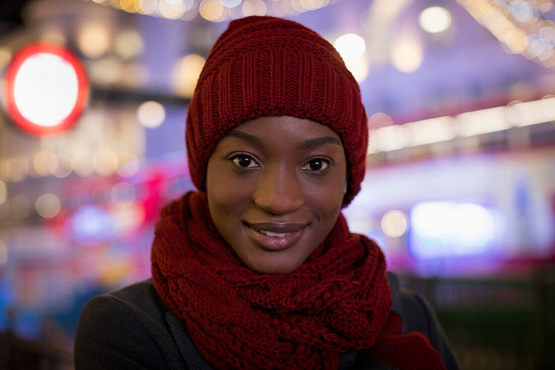 Confident young woman in red knit hat and scarf