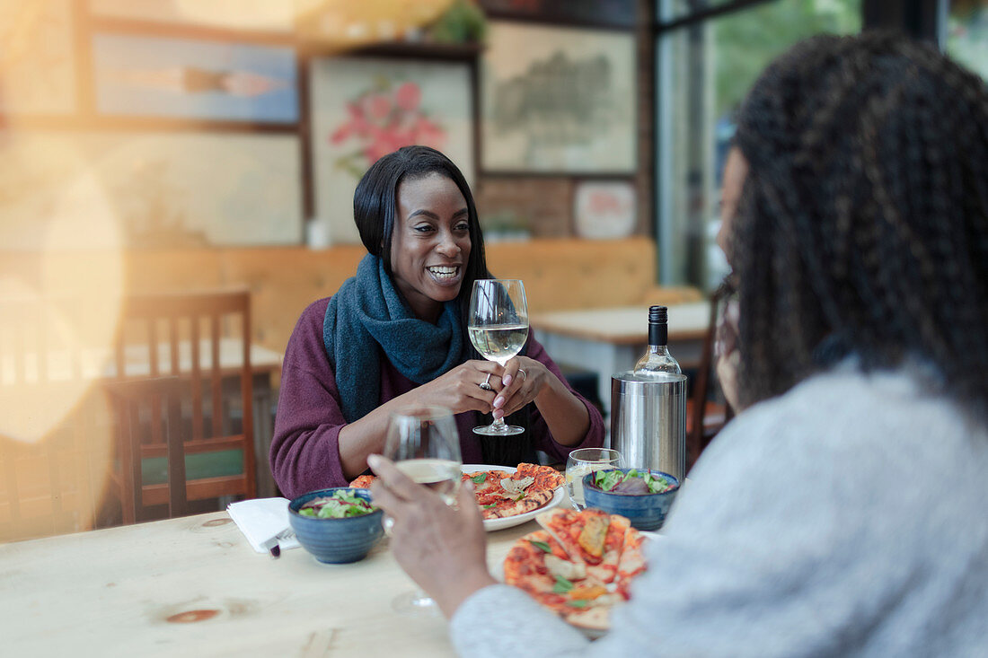 Mother and daughter enjoying wine and pizza at lunch