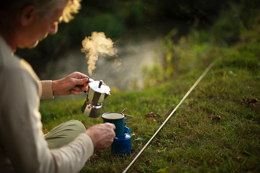 Man taking a break from fishing by making hot coffee