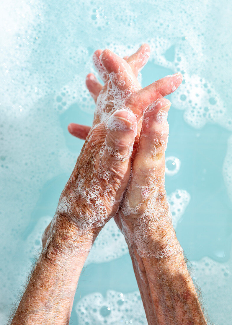Close up senior woman washing hands in soapy water