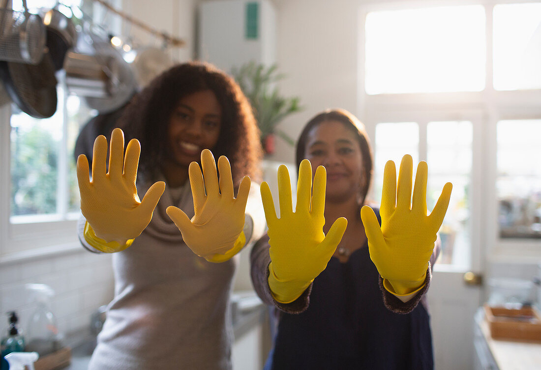 Mother and daughter gesturing in yellow rubber gloves