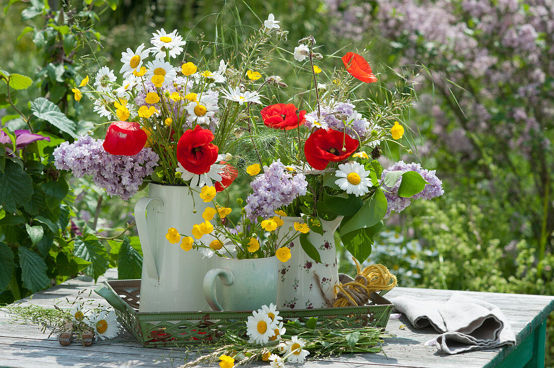 Early summer bouquets of daisies, corn poppies, buttercups, lilacs and white campion