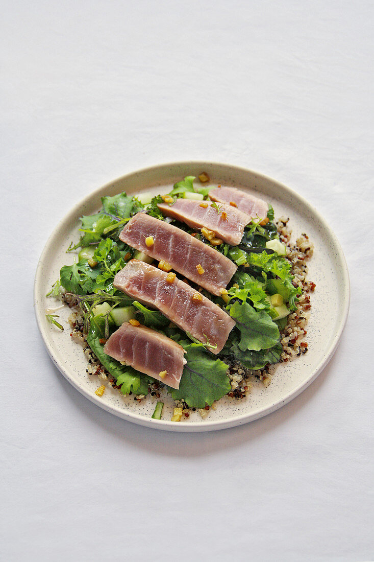 Sesame coated tuna steak on quinoa with salad and green salsa