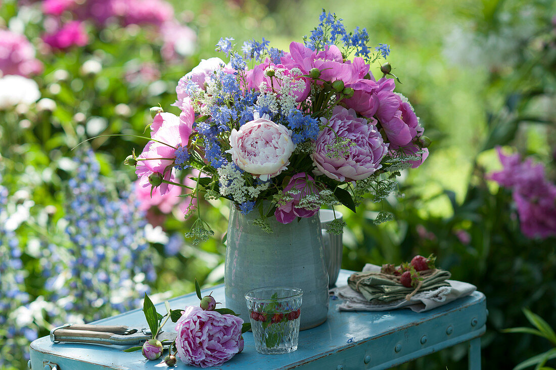 Early summer bouquet of peonies, speedwell and ground elder on side table