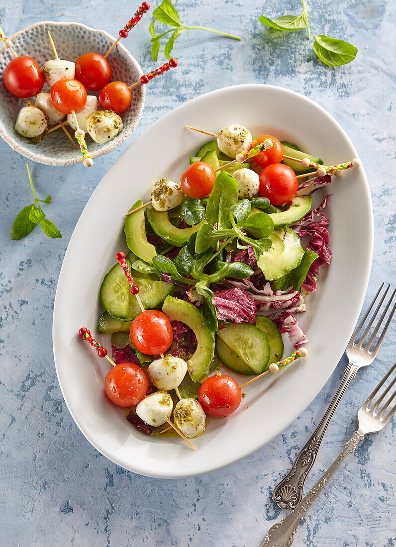 Salat mit mariniertem Mozzarella, Tomate und Gurke