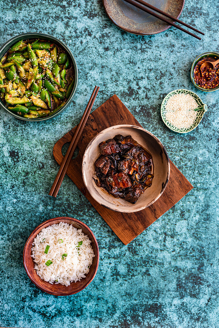 Geschmorter Schweinebauch mit Gurkensalat, Reis, Chiliöl und Sesam (Asien)