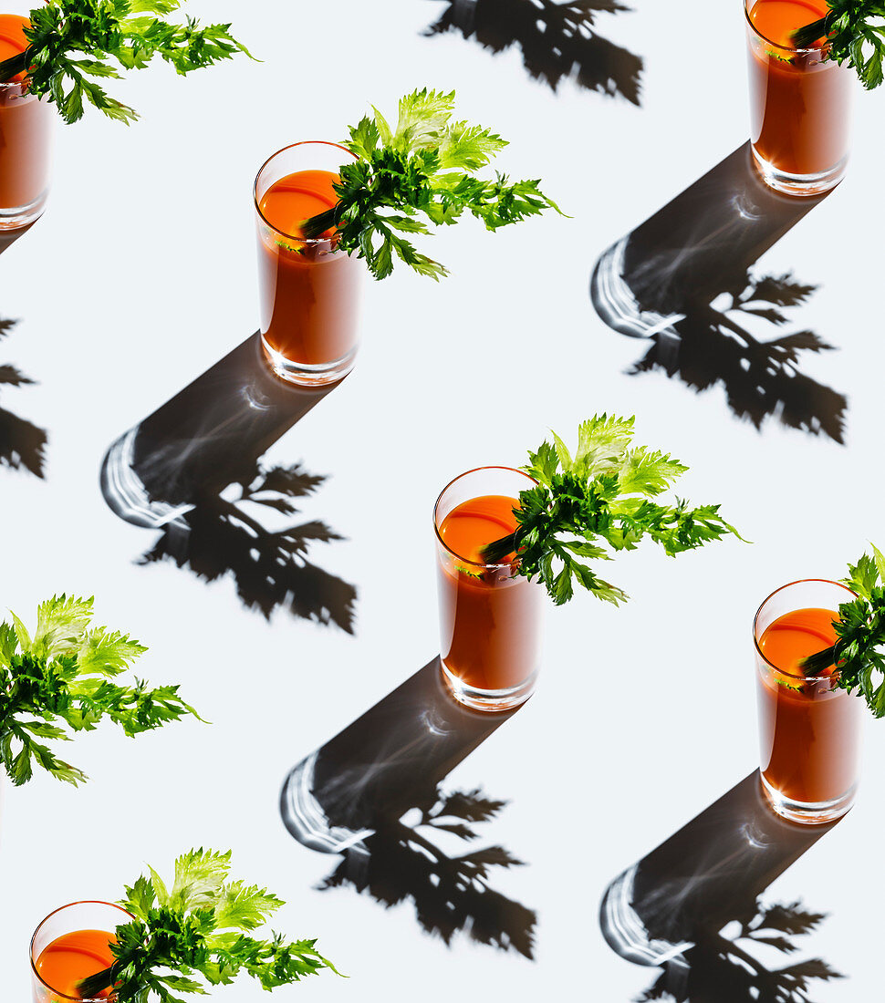 Carrot juice with celery on gray background Pattern