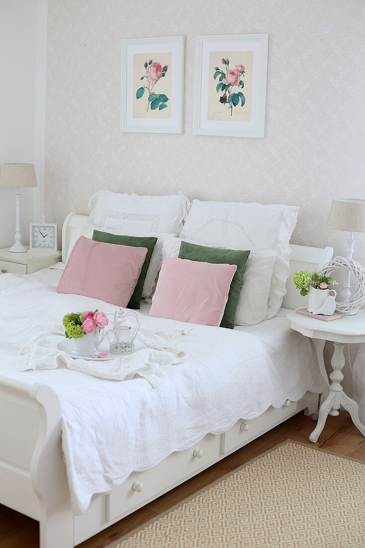 Tray with flowers on double bed with white blanket