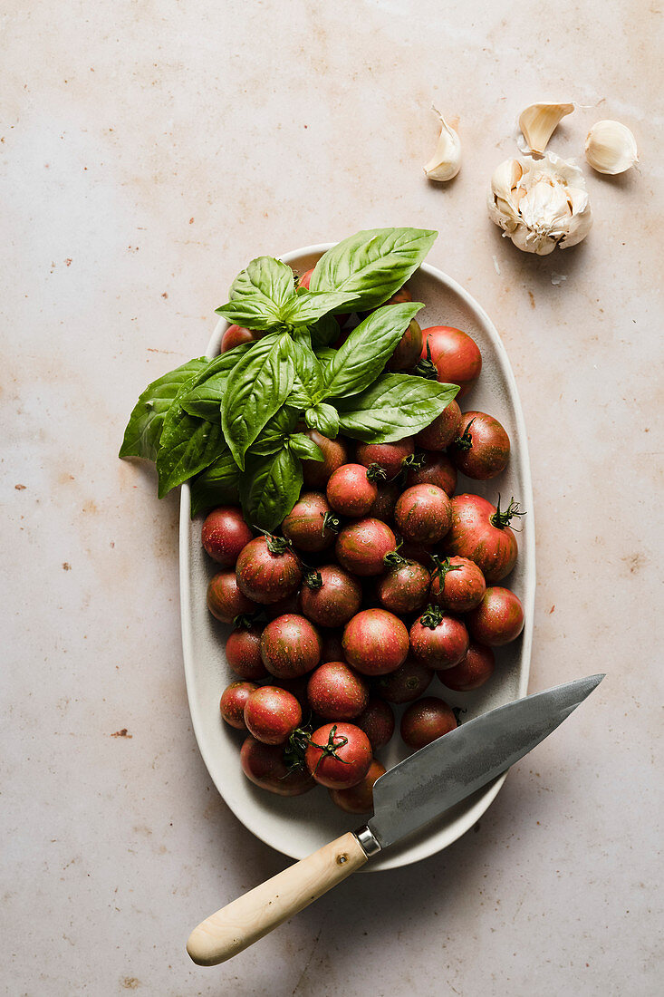 Cherry tomatoes in a bowl with basil and garlic