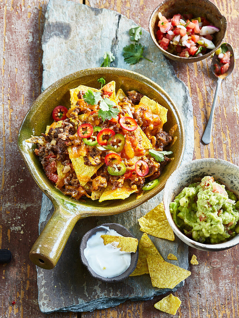 Nachos with mincemeat, cheese and two sauces