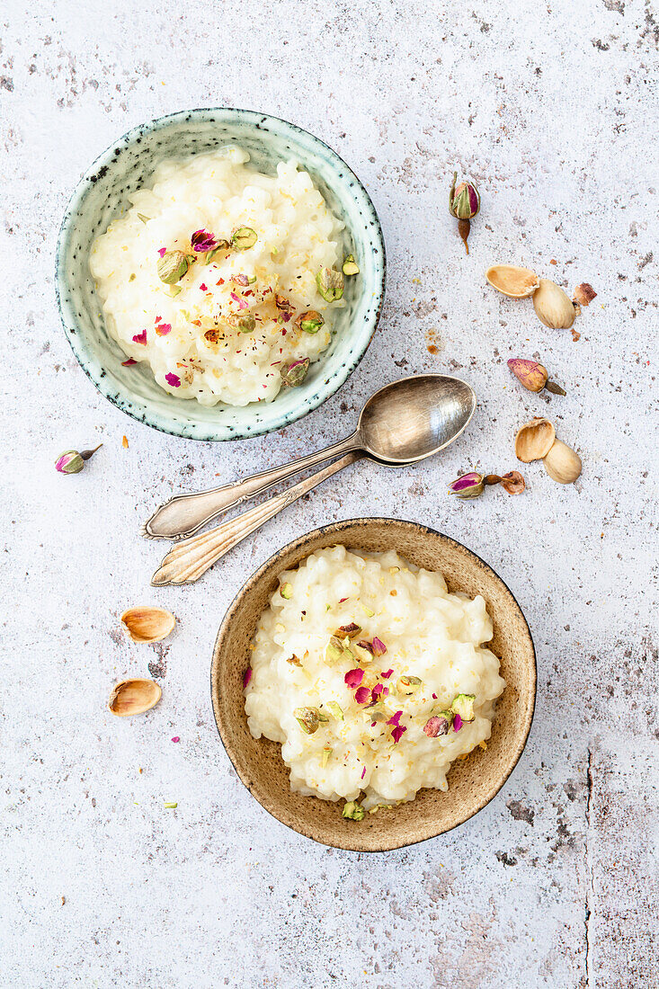 Griechischer Milchreis mit Rosenwasser, getrockneten Rosenblüten und Pistazien