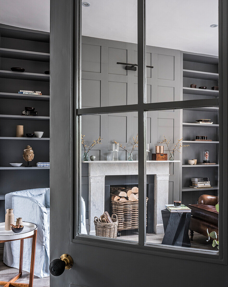 Blick durch offene Sprossentür ins klassische Wohnzimmer in Grau