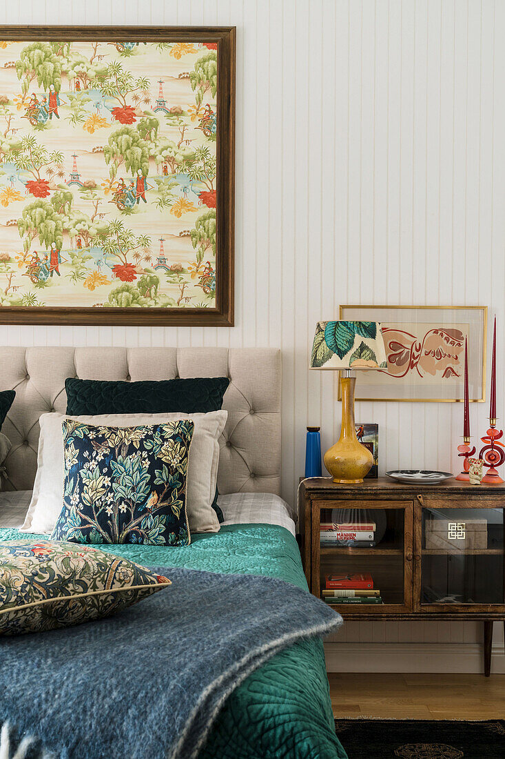 Double bed, Chinese fabric in picture frame above and bedside cabinet in bedroom