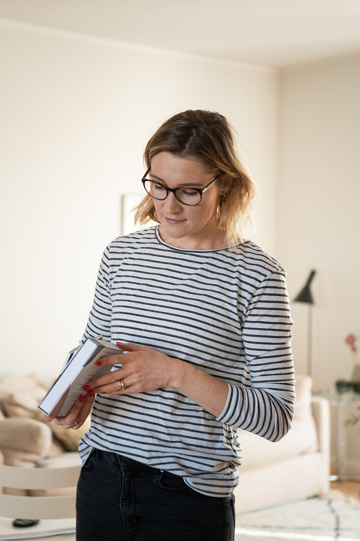 Blonde Frau hält ein Buch in der Hand