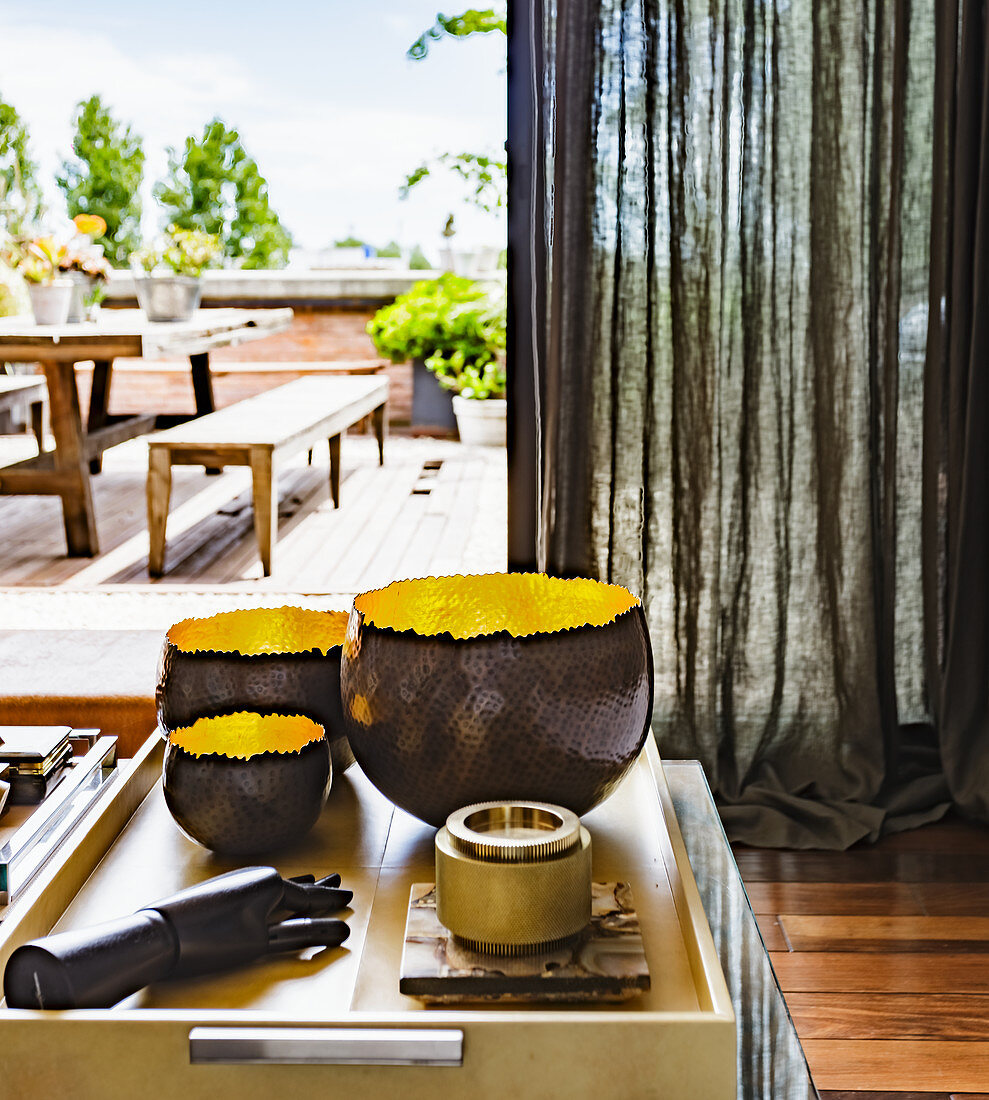 Bowls and decorative hand model on coffee table in front of a linen curtain