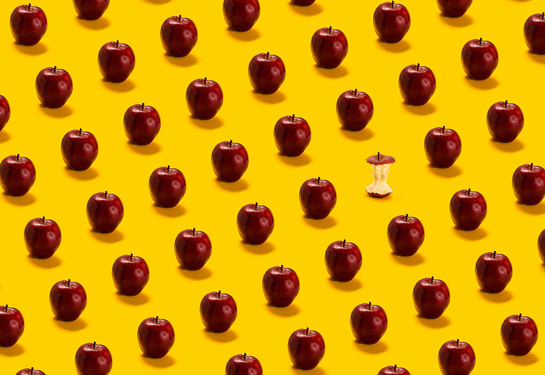 Viele rote Äpfel und ein Apfelputzen auf gelbem Hintergrund
