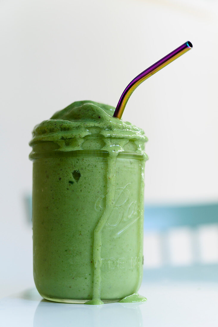 Grüner Smoothie mit Strohhalm