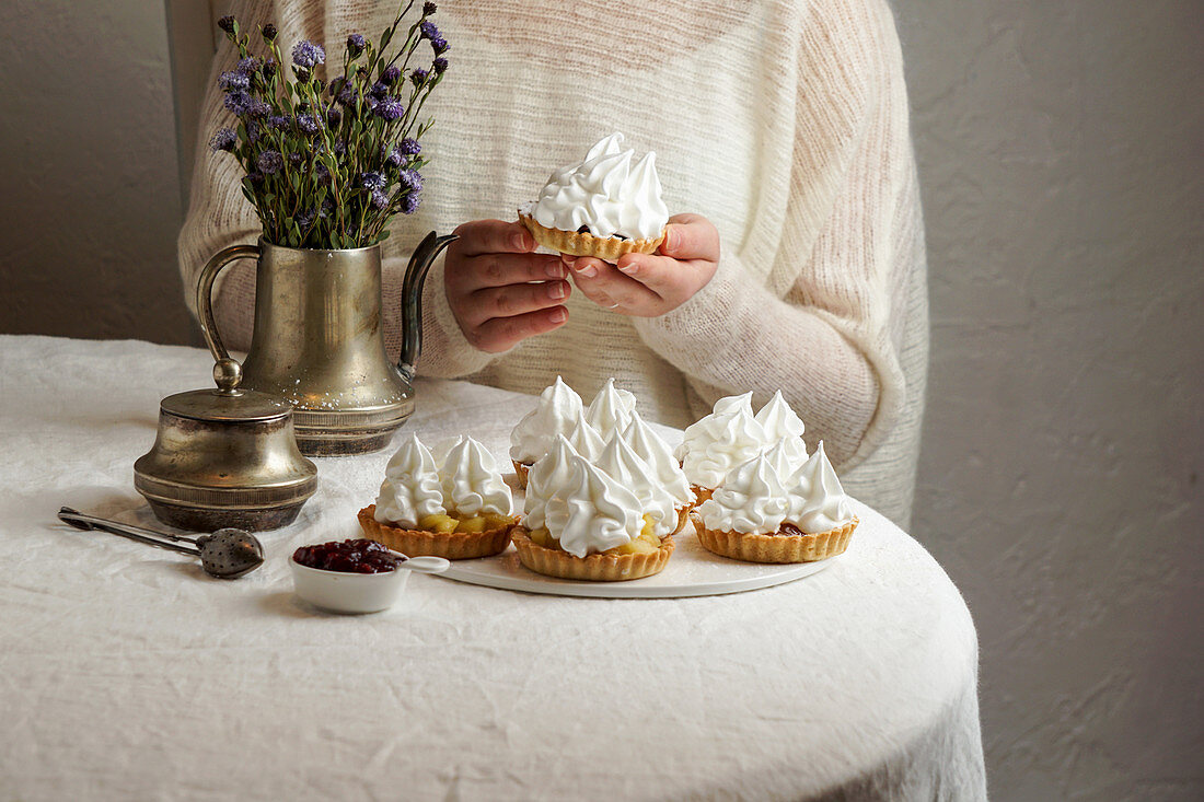 Decorating tartlets with cream and meringue icing