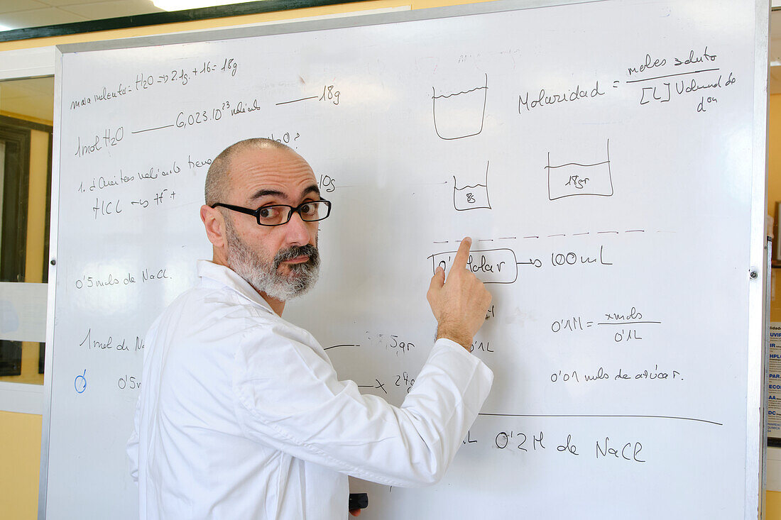 Teacher explaining chemistry on a whiteboard