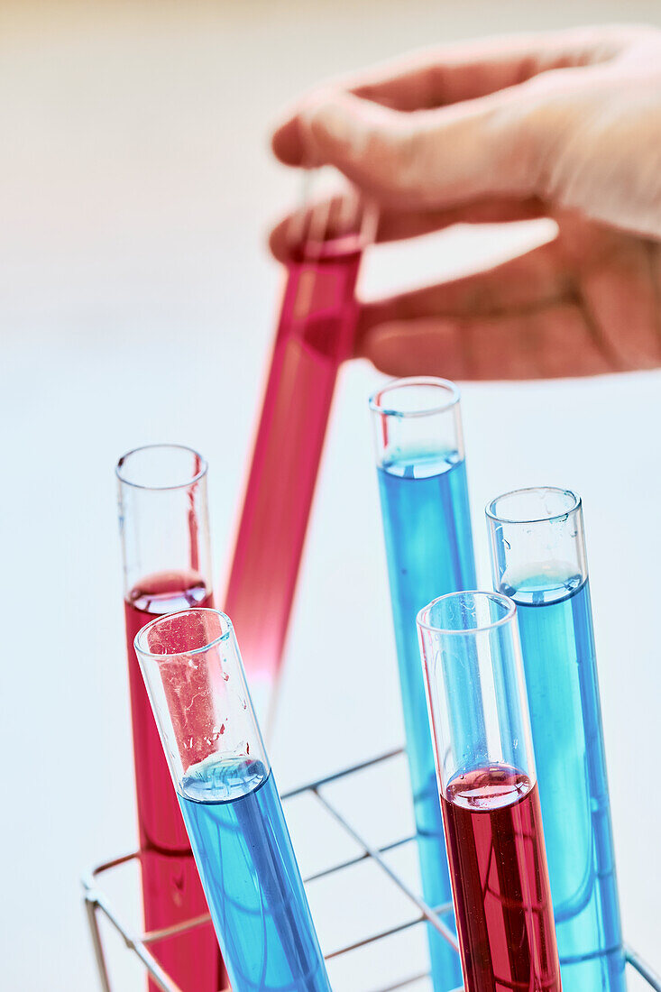 Person holding a test tube with dye liquid