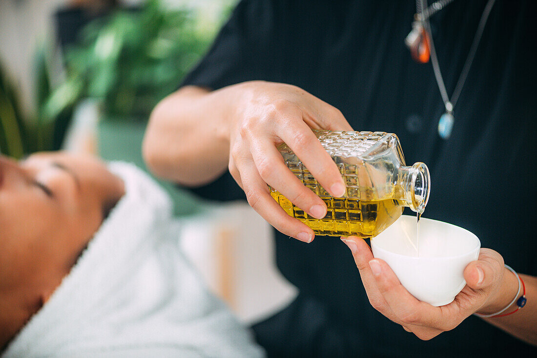 Pouring ethereal ayurvedic oil into a bowl