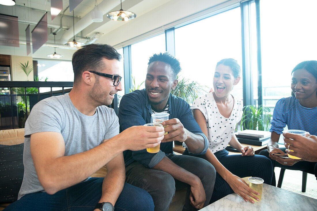 Happy business people celebrating with beers in office