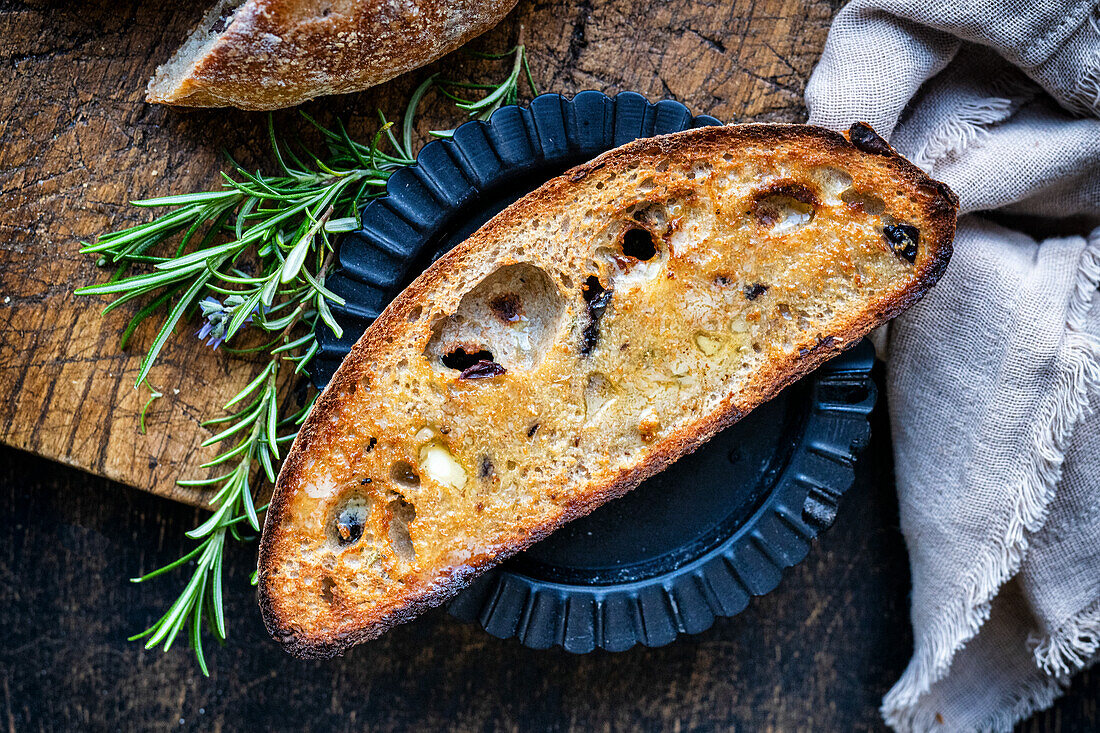 A toasted slice of sourdough olive bread