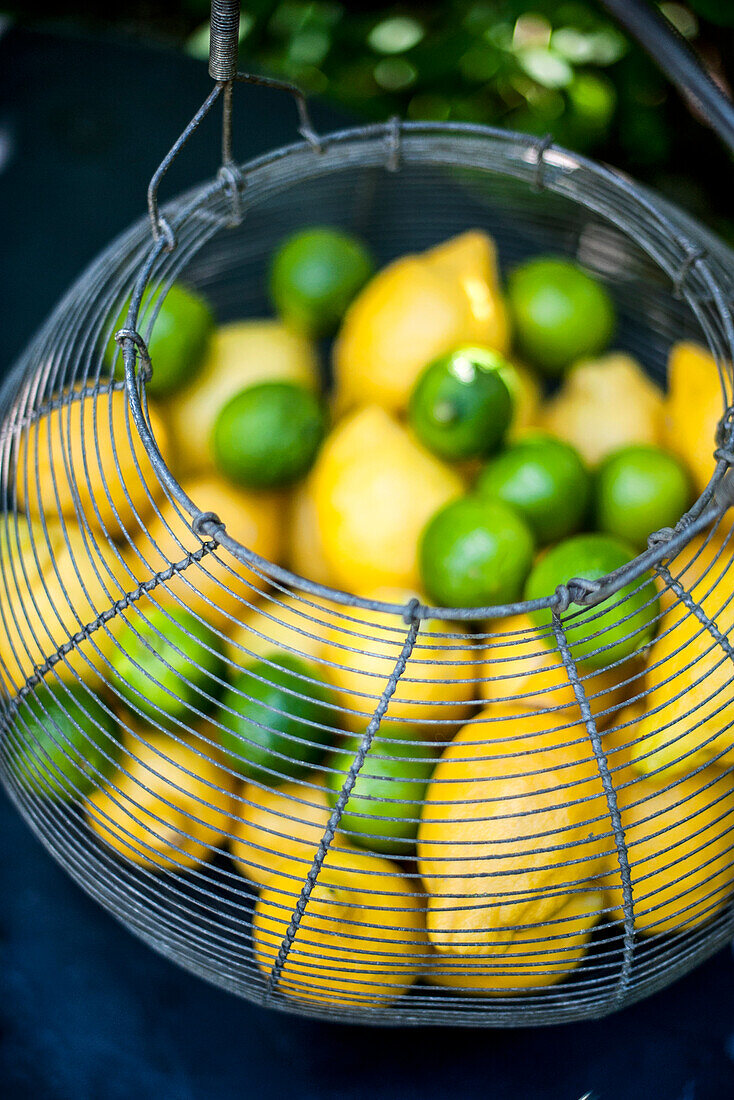 Zitronen und Limetten in Drahtkorb
