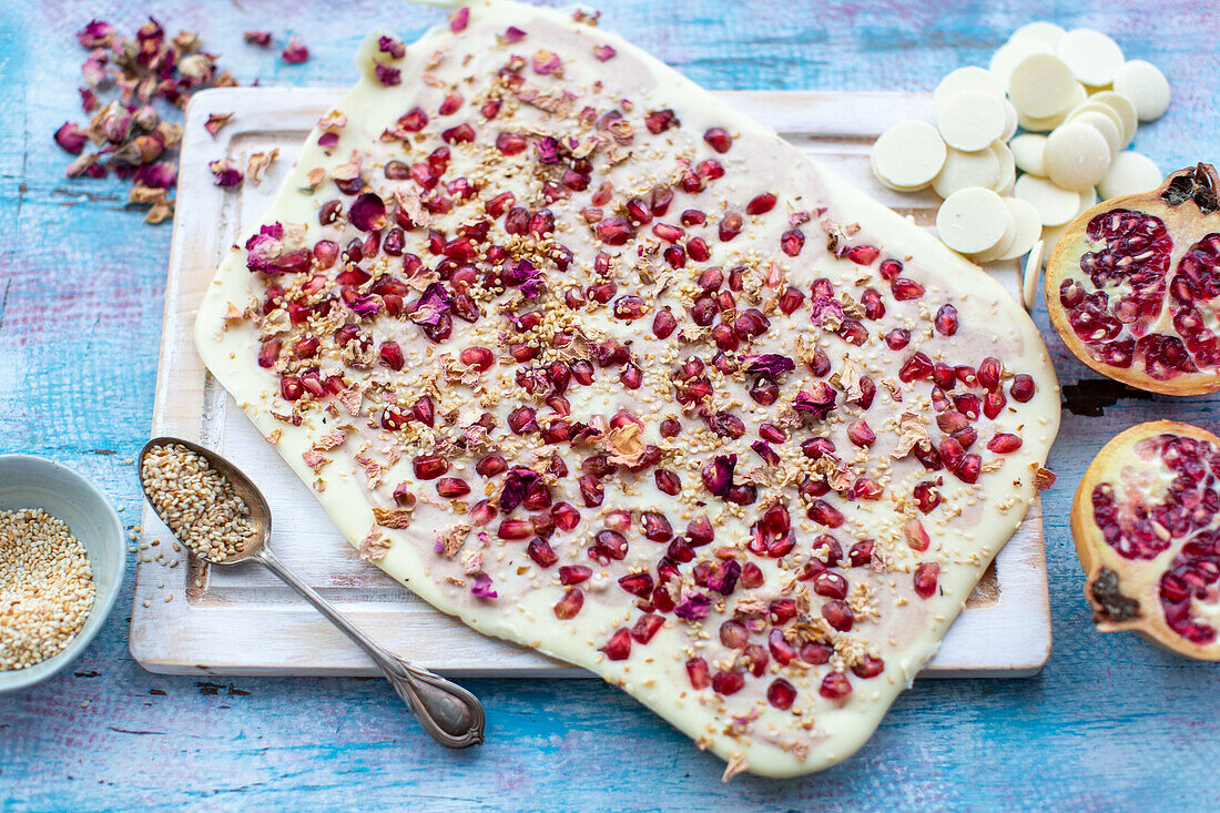 Weiße Bruchschokolade mit Granatapfelkernen und Rosenblättern