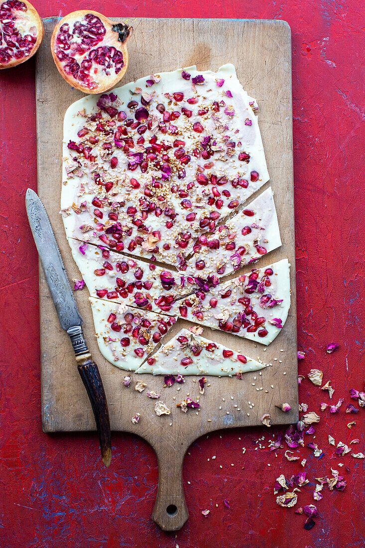 Weiße Bruchschokolade mit Granatapfelkernen und Rosenblättern