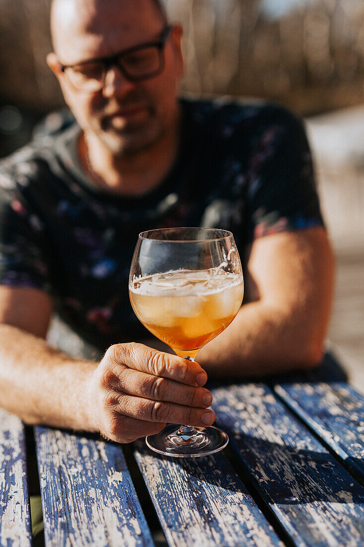 Mann mit einem Glas Cocktail im Freien