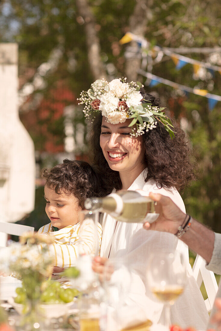 Young woman with flower wreath and little boy (summer solstice party, Sweden)