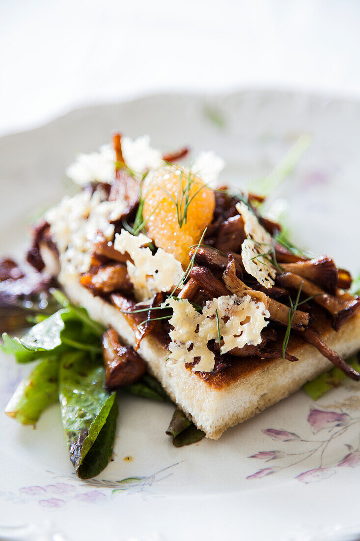 Bread with chanterelles and parmesan chips on salad