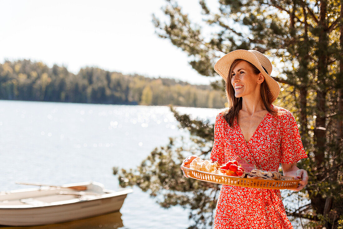 Smiling woman carrying tray with food