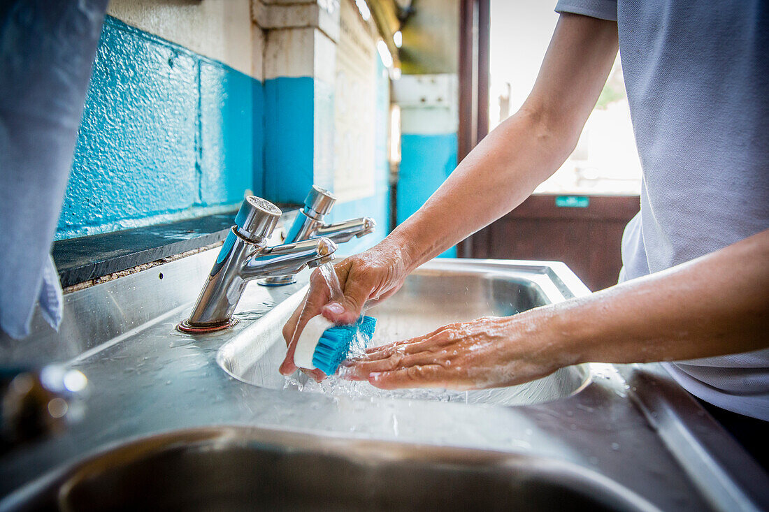 Nägel unter Wasser mit Bürste reinigen