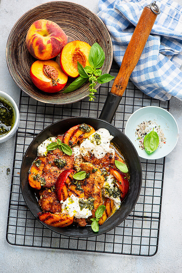 Grilled peaches and chicken with burrata garnished with pesto