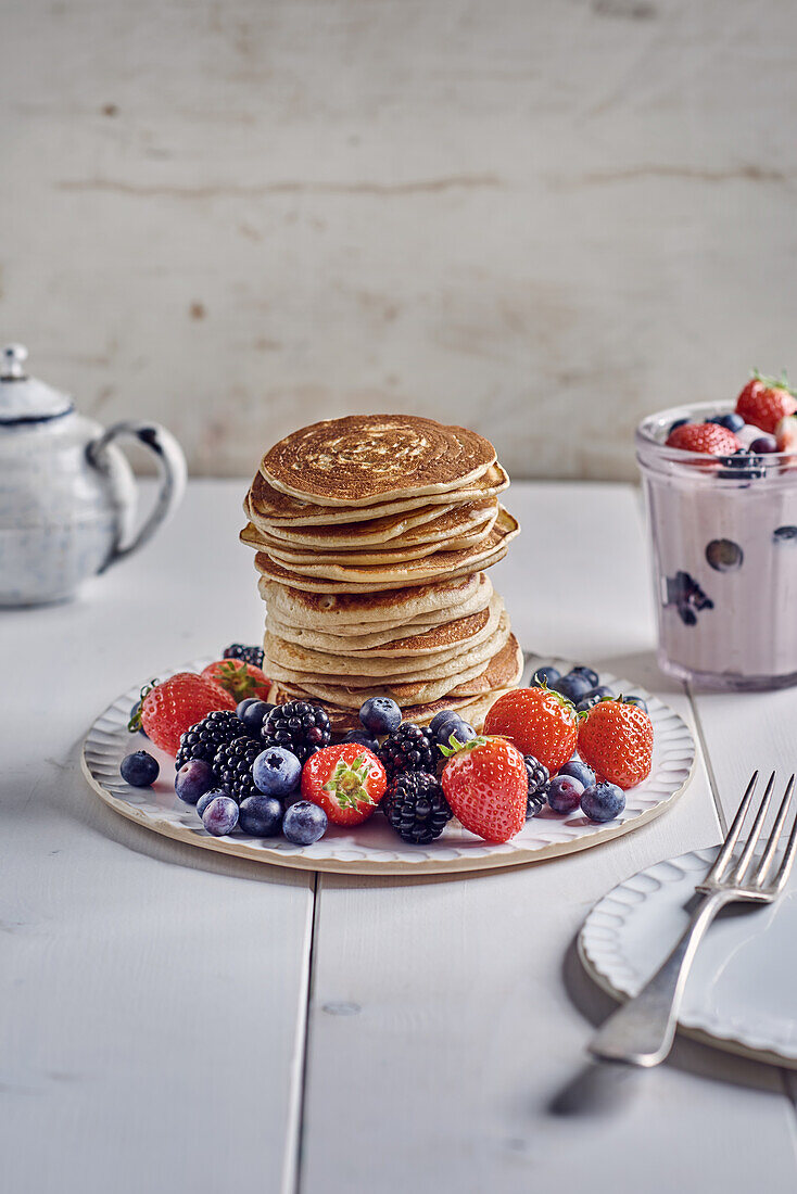 Ein Stapel Pancakes mit frischen Beeren und Erdbeerjoghurt