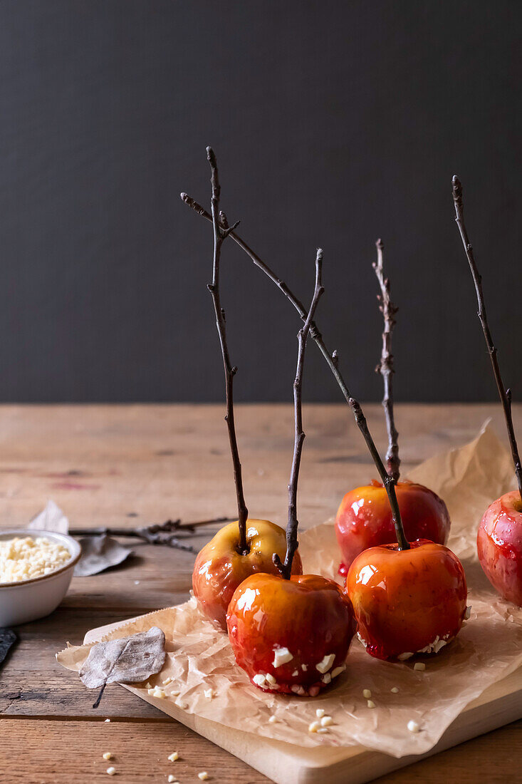 Candied apples on parchment paper on wooden table
