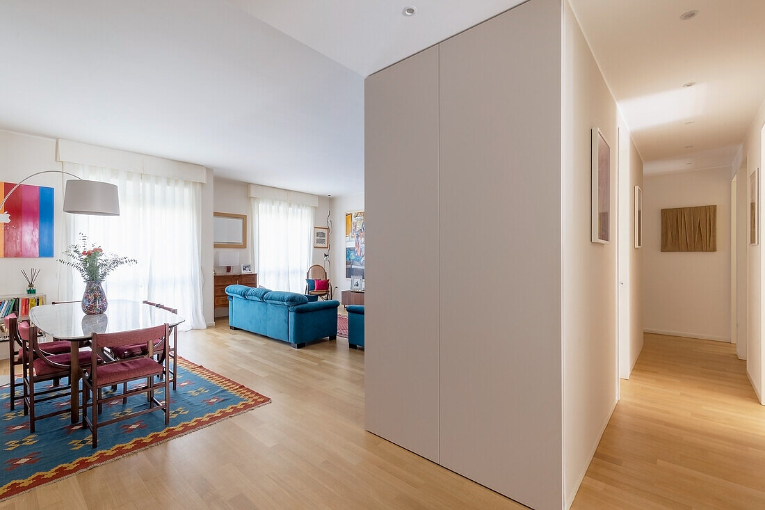 Open-plan interior with dining area, blue sofa in background and modular elements